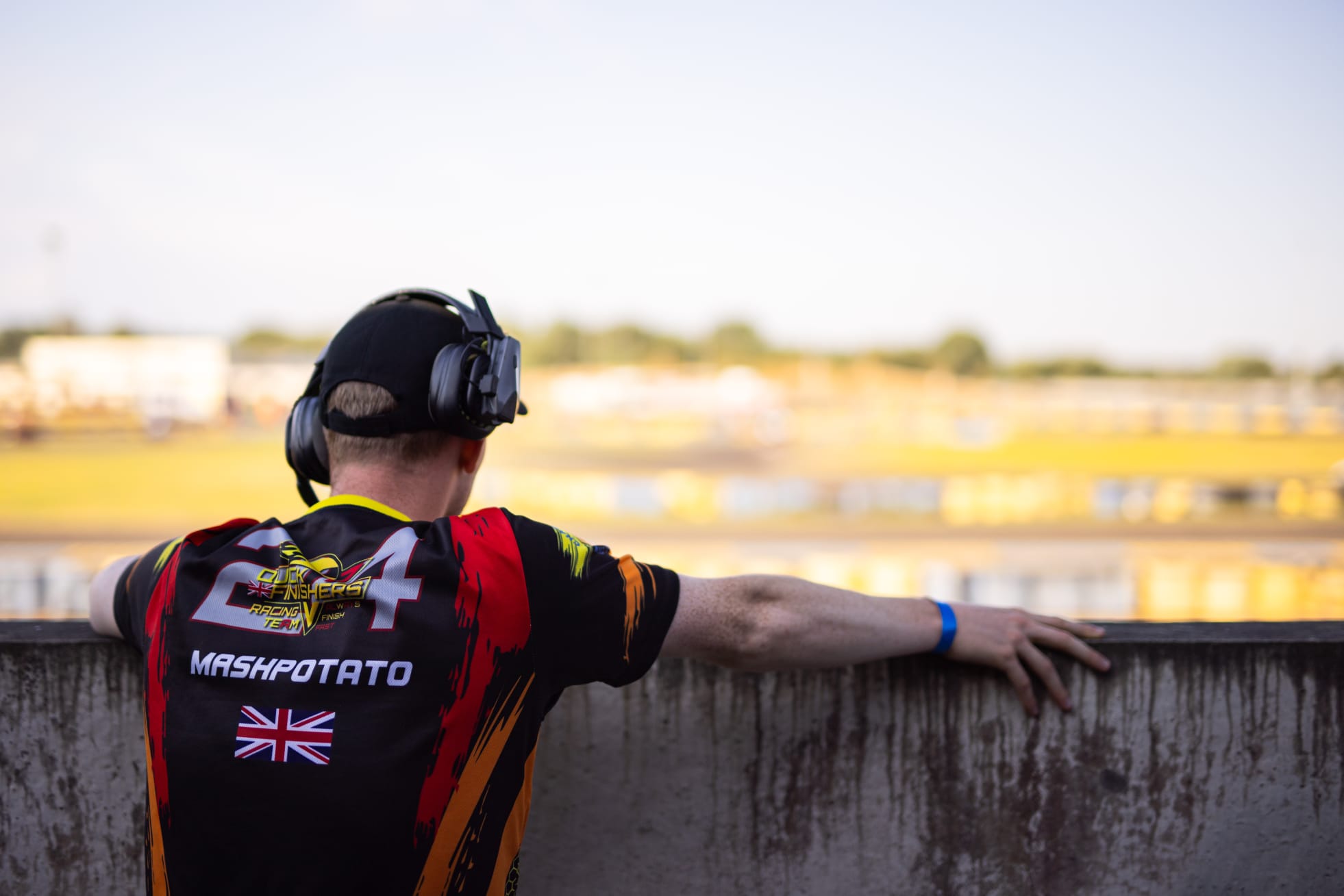 Racer in a Mashpotato team jersey watching the action from trackside